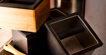 Rattleware stainless steel and wood knock boxes on a cafe counter